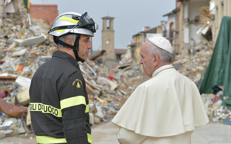 Pope Francis talks with a firefighter Oct. 4 in Amatrice, Italy. (CNS/L'Osservatore Romano) 