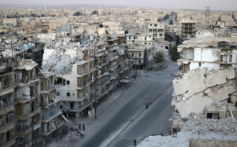 People walk past destroyed buildings Oct. 5 in Aleppo, Syria (CNS/Abdalrhman Ismail, Reuters)  