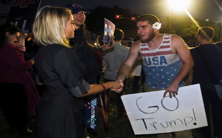 Shannon Kelly, a protester demonstrating against U.S. President-elect Donald Trump, shakes hands with Trump supporter Ben Kilgore after a long discussion about the billionaire's qualifications at the Capitol in Tallahassee, Fla. Bishops across the country are encouraging people to put aside their differences and work for the common good as Trump prepares for his Jan. 20 inauguration. (CNS photo/Phil Sears, Reuters)