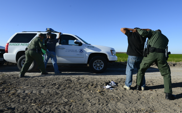 U.S. Border Patrol agents apprehend and search two people in 2013 who were suspected of entering the U.S. illegally by crossing the Rio Grande River near McAllen, Texas. In a joint statement, Catholic bishops whose dioceses are along the U.S.-Mexico border called for respecting people's dignity regardless of "migration condition." (CNS photo/Larry W. Smith, EPA)