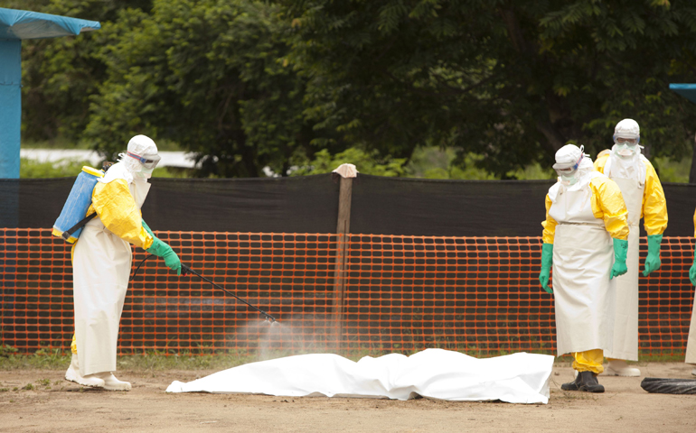 Medical personnel spray disinfectant on the body of a person who died from the Ebola virus in this undated photo in Foya, Liberia. (CNS/Reuters/Samaritan's Purse)