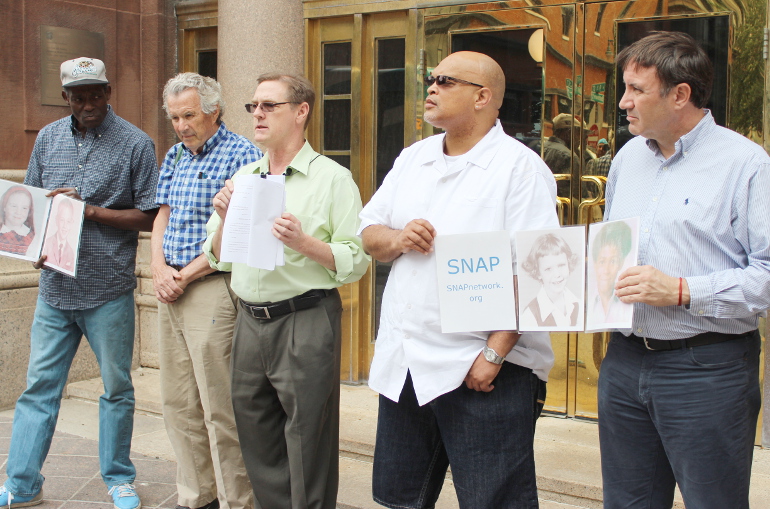 David Clohessy, center, executive director of Survivors Network of those Abused by Priests, stands with survivors of clerical sexual abuse during a press conference at the Kansas City-St. Joseph Catholic Chancery Wednesday. (NCR photo/Nicholas Sciarappa)