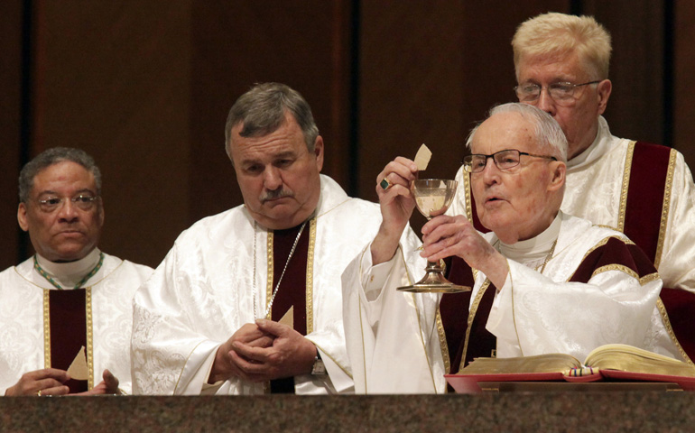 Retired Auxiliary Bishop Timothy Lyne of Chicago raises the host as he celebrates Mass in early May at Holy Name Cathedral in Chicago. (CNS photo/Catholic New World/Karen Callaway)