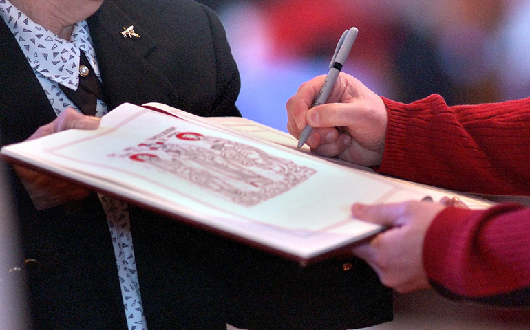 A catechumen signs the Book of the Elect during the Rite of Election, part of the Rite of Christian Initiation of Adults (CNS file photo/The Dialog/Don Blake)