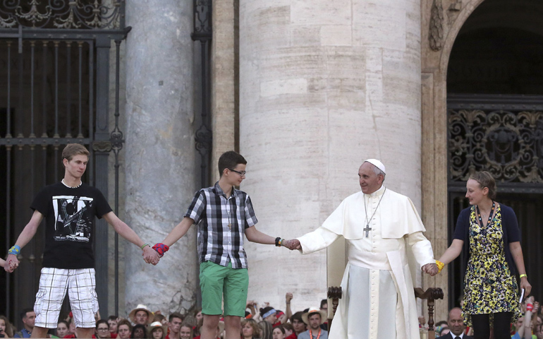 Pope Francis holds hands with young people during a meeting with altar servers Tuesday in St. Peter's Square at the Vatican. (CNS/Reuters/Stefano Rellandini)