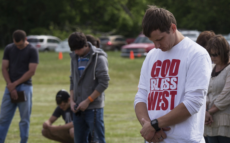 Town residents bow their heads in prayer during an April 21 outdoor prayer service four days after a deadly fertilizer plant explosion in the town of West, near Waco, Texas. (CNS/Reuters/Adrees Latif)