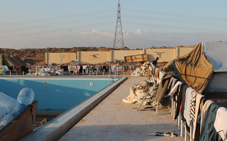 Blankets line a fence where Iraqi Christians are sheltered by Dominican Sisters of St. Catherine of Siena outside a youth sport center in Ainkawa, Iraq. (CNS/Dale Gavlak) 