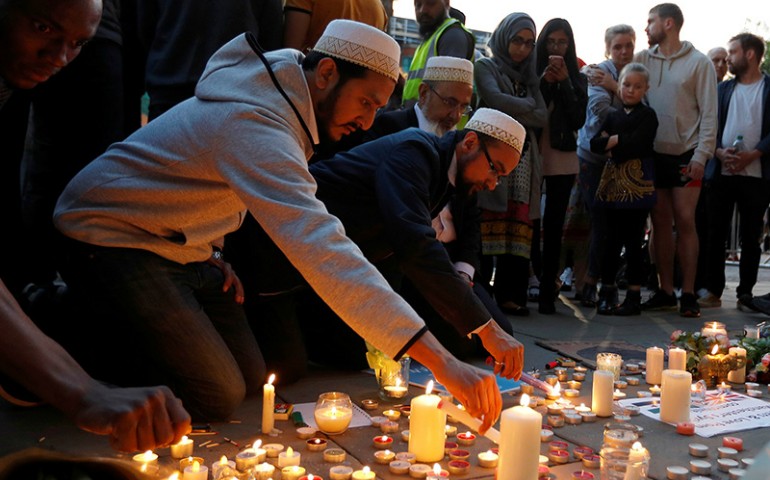 Men light candles following a vigil in central Manchester, Britain, on May 23, 2017. (Reuters/Peter Nicholls)