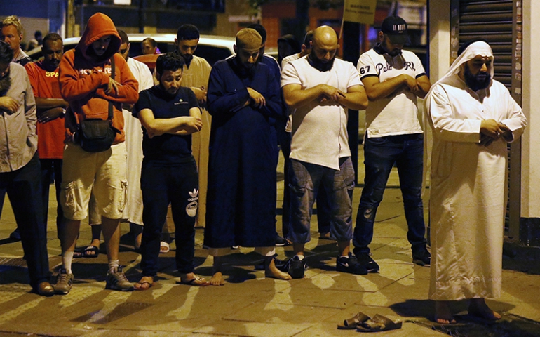 Men pray after a vehicle collided with pedestrians near a mosque in the Finsbury Park neighborhood of North London, Britain, on June 19, 2017. (Courtesy of Reuters/Neil Hall