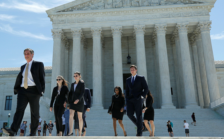 People walk out after the U.S. Supreme Court granted parts of the Trump administration's emergency request to put his travel ban into effect immediately while the legal battle continues, on June 26, 2017, in Washington, D.C. (Photo by Yuri Gripas/Reuters)