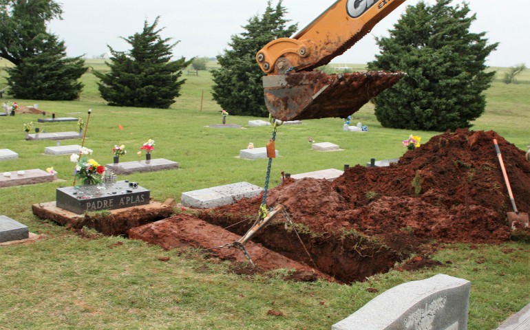 The vault containing Fr. Stanley Rother's original casket is lifted from its gravesite at Holy Trinity Cemetery May 9 in Okarche, Okla. (CNS/Diane Clay, Sooner Catholic)