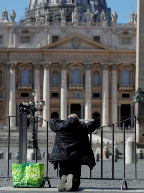 A man prays in front of an empty St. Peter's Square in Rome March 25. (CNS/Reuters/Guglielmo Mangiapane)