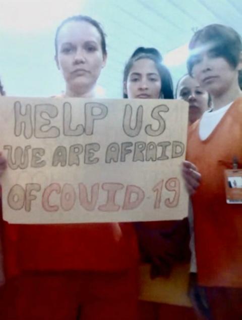 Migrants detained in an Immigration and Customs Enforcement facility in Basile, Louisiana, display signs April 3 related to the coronavirus disease. (CNS/Handout via Reuters)