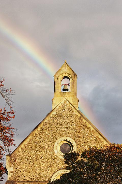A rainbow over a church steeple with bell (Unsplash/Metin Ozer)
