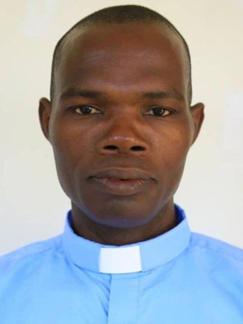 Plain headshot of Fr. Yugue wearing blue shirt and collar. 