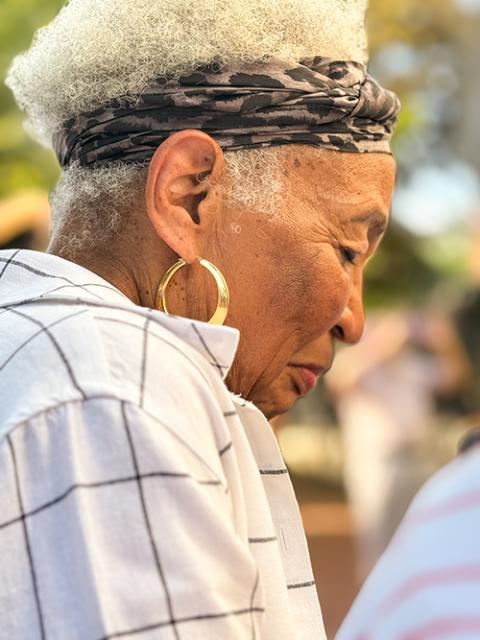 Sondra Raspberry bows her head in prayer during a June 19 ceremony outside Holy Trinity Catholic Church in Washington unveiling a plaque acknowledging the parish's history of segregation. (NCR photo/Rhina Guidos)