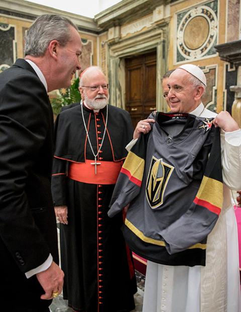 Pope Francis accepts a jersey from Tim Busch during an audience with members of the Papal Foundation at the Vatican May 10, 2019. Looking on is Boston Cardinal Sean O'Malley. (CNS/Vatican Media)