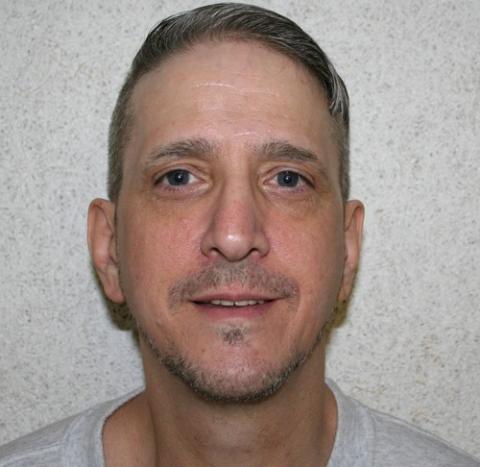 Head shot of Glossip against gray wall, smiling. 