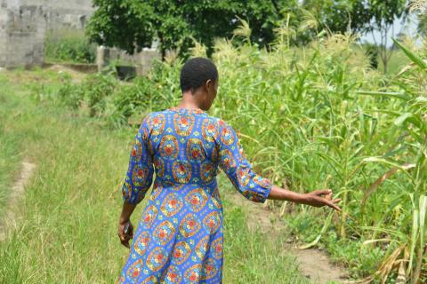 A local farmer affected by oil spills stands in the middle of her farmland. 