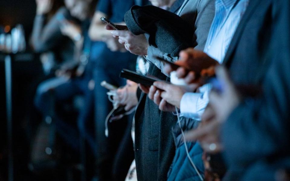 line of people staring at smartphones