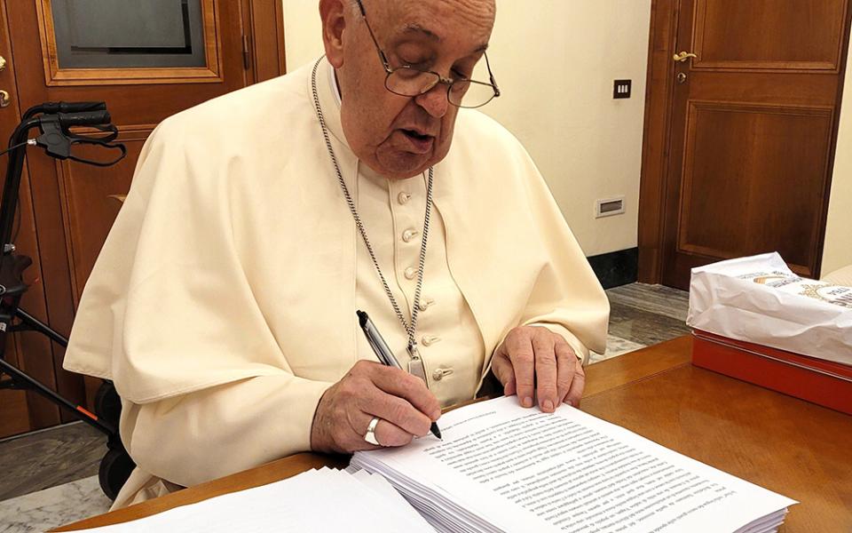 Pope Francis reviews and initials each page of the manuscript of "Hope: The Autobiography" Aug. 9, 2024, in his Vatican residence, the Domus Sanctae Marthae. The book was released in multiple languages Jan. 14, 2025. (CNS/Courtesy of Mondadori)