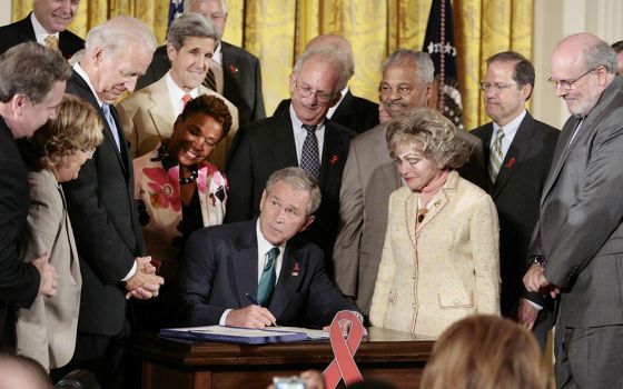 President George W. Bush signs a bill that extends the President’s Emergency Program for AIDS Relief, known as PEPFAR, surrounded by lawmakers and other supporters of the program at the White House in Washington July 30, 2008. (CNS/Reuters/Larry Downing)