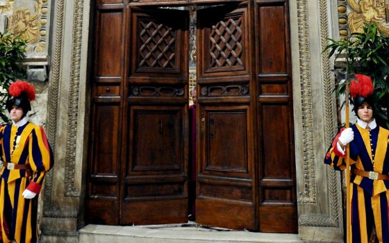 Swiss Guards stand in front of the doors to the Vatican's Sistine Chapel as cardinals begin the conclave to elect a successor to Pope Benedict XVI in March 2013. (CNS/L'Osservatore Romano via Reuters)