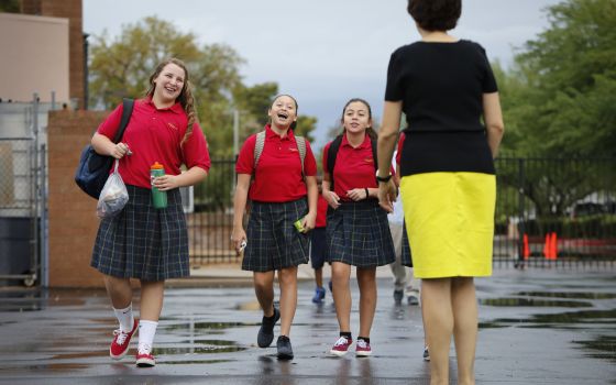 Girls greet a teacher as they arrive for class at St. Jerome Catholic School in Phoenix. More than 1.9 million U.S. students were returning to Catholic elementary, middle and secondary schools this academic year, according to the National Catholic Educati