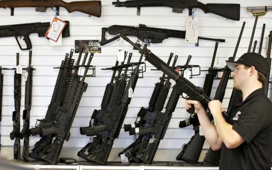 A salesman clears the chamber of an AR-15 in 2016 at a gun store in Provo, Utah (CNS/Reuters/George Frey)