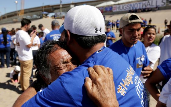 Relatives embrace as they take part in a brief reunification meeting May 2 on the border between Ciudad Juarez, Mexico, and El Paso, Texas. (CNS/Reuters/Jose Luis Gonzalez)