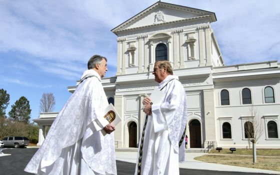 Fr. David Dye, retired administrator of Mary Our Queen Church in Peachtree Corners, Georgia, and Fr. Francis "Butch" Mazur, the last pastor of St. Gerard Church in Buffalo, New York, discuss the new Mary Our Queen Church in the background. (CNS)