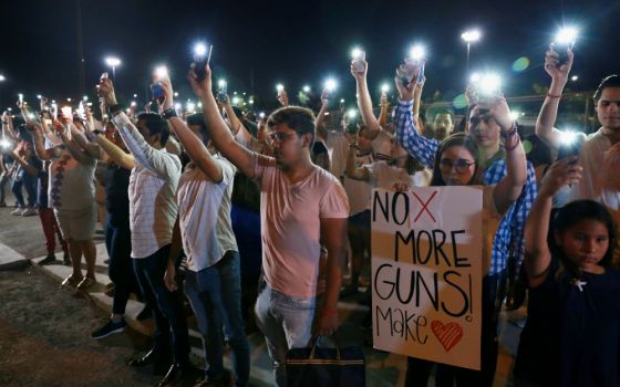 Mourners take part in a vigil near the border fence between Mexico and the U.S. after a mass shooting at a Walmart store in El Paso, Texas, Aug. 3. (CNS/Reuters/Carlos Sanchez)