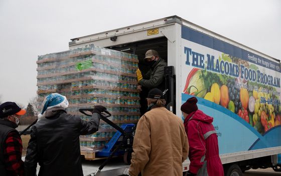 Volunteers from Forgotten Harvest food bank in Warren, Michigan, unload goods before a mobile food pantry distribution Dec. 21, 2020, amid the coronavirus pandemic. (CNS/Reuters/Emily Elconin)