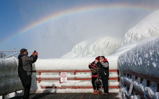 Visitors are photographed at the base of American Falls in Niagara Falls, New York, Feb. 21. (CNS/Reuters/Lindsay DeDario)