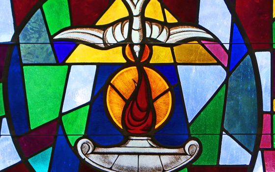 The Holy Spirit and a lantern flame symbolizing the sacrament of confirmation are depicted in a stained-glass window at Sts. Cyril & Methodius Church in Deer Park, New York. (CNS/Gregory A. Shemitz)