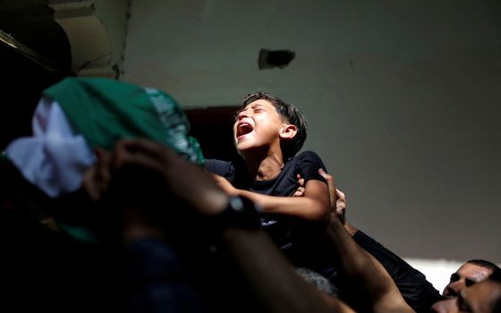 The brother of Palestinian Ahmed al-Shenbari, who was killed during Israeli-Palestinian violence, cries during his funeral in the Gaza Strip May 11. (CNS/Reuters/Mohammed Salem)