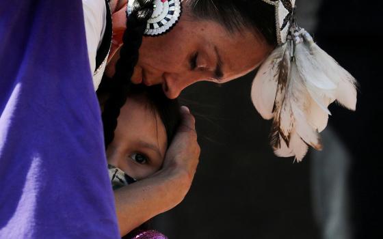 A woman embraces her daughter during a rally at the former Kamloops Indian Residential School in Kamloops, British Columbia, June 6. (CNS/Reuters/Chris Helgren)