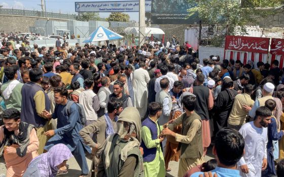 People try to get into Hamid Karzai International Airport Aug. 16 in Kabul, Afghanistan. (CNS/Reuters)