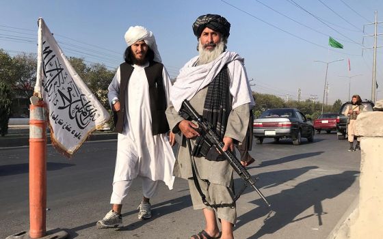 Taliban fighters stand outside the Interior Ministry in Kabul, Afghanistan, Aug. 16. (CNS/Reuters)