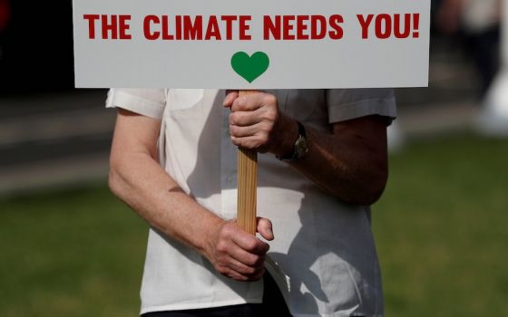 A protester from the Climate Coalition demonstrates in Parliament Square in London July 23. Catholics were among dozens of leaders from the major faiths in the United Kingdom who signed the Glasgow Multifaith Declaration ahead of the U.N. Climate Change C