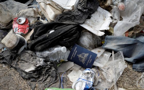 A Haitian passport is seen in a pile of trash Sept. 21, 2021, in Del Rio, Texas, near the International Bridge between Mexico and the United States. (CNS photo/Marco Bello, Reuters)