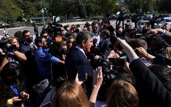 Sen. Joe Manchin, D-W.Va., makes his way through a crowd of Capitol Hill reporters outside the U.S. Capitol Sept. 30 in Washington. (CNS /Reuters/Leah Millis)