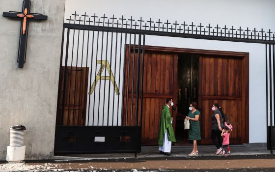 A priest talks with parishioners before celebrating Mass in the Church of San Isidoro in La Palma, Spain, Sept. 25, 2021. (CNS photo/Nacho Doce, Reuters)