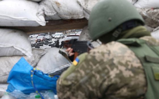 A member of the Territorial Defense Forces in Kyiv, Ukraine, stands guard at a checkpoint March 3, as Russia's invasion of Ukraine continues. (CNS/Reuters/Mykola Tymchenko)