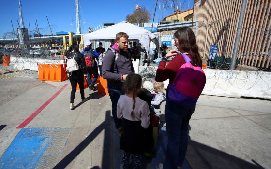 A Ukrainian family waits for a humanitarian visa outside the San Ysidro Port of Entry at the U.S.-Mexico border in Tijuana, Mexico March 11, 2022. (CNS photo/Jorge Duenes, Reuters)