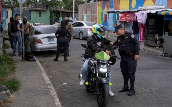 A Salvadoran police officer searches a man at a checkpoint in San Salvador March 30, 2022. (CNS photo/Jose Cabezas, Reuters)