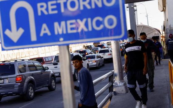 Migrants expelled from the U.S. and sent back to Mexico under Title 42 walk toward Mexico at the Paso del Norte International border bridge in Ciudad Juarez, Mexico, May 21, 2022. (CNS photo/Jose Luis Gonzalez, Reuters)