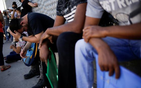 Migrants are seen outside the National Migration Institute in Ciudad Juarez, Mexico, July 8, 2020, where they had to renew their permission to stay in Mexico while awaiting an immigration hearing in the United States. (CNS/Reuters/Jose Luis Gonzalez)