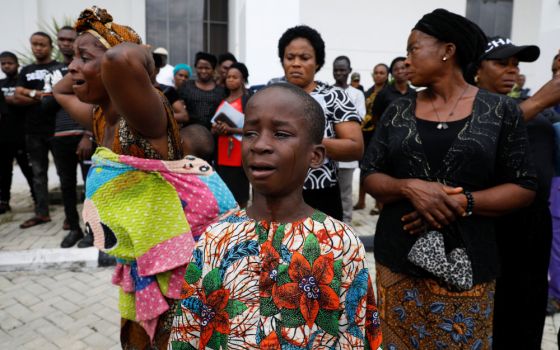 A woman and child cry following a funeral Mass in the parish hall of St. Francis Xavier Church in Owo, Nigeria, June 17. The Mass was for some of the 40 victims killed in a June 5 attack by gunmen during Mass at the church. (CNS/Reuters/Temilade Adelaja)