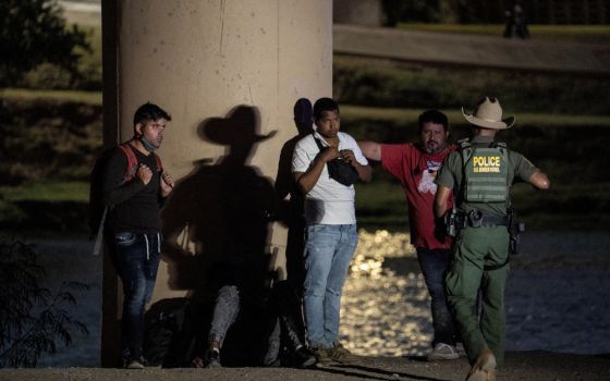 Migrants in Eagle Pass, Texas, wait to be transported by U.S. Customs and Border Protection agents after crossing the Rio Grande July 26, 2022.